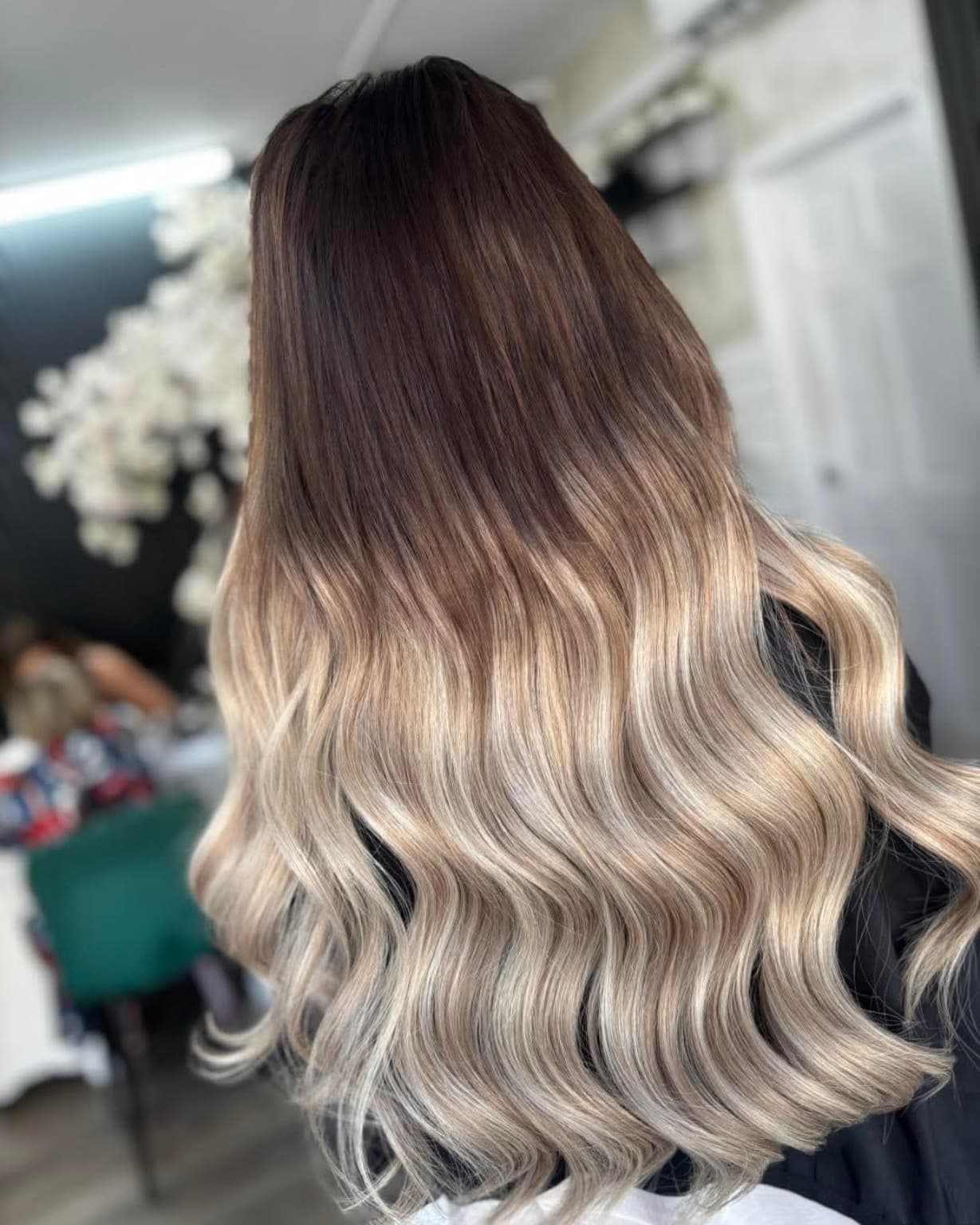 Blonde colour-matched hair extensions styled in soft waves
